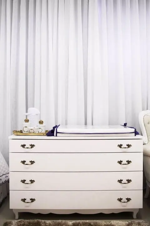 Cômoda retrô branca com puxadores de ferro em quarto de bebê Projeto de Maria Laura Coelho