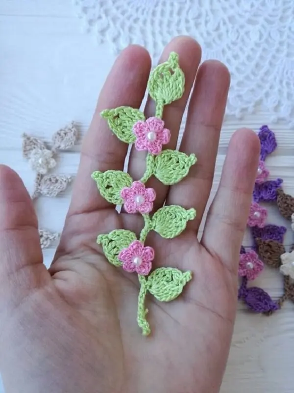 Folhas e flores pequeninas de crochê formam um lindo arranjo