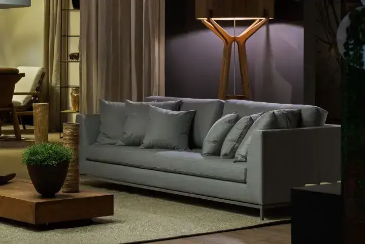Luminária de madeira de piso atrás de sofá cinza em sala de estar Projeto de Morar Mais Por Menos Goiânia