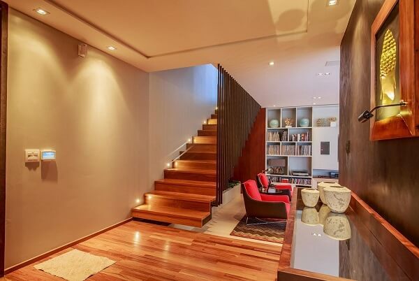 O spot de luz embutido traz um toque sofisticado para a escada com degraus de madeira. Fonte: WT Studio