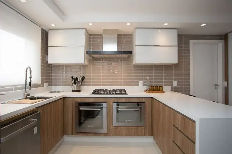cozinha compacta com azulejo tipo tijolinho e armário de cozinha de parede