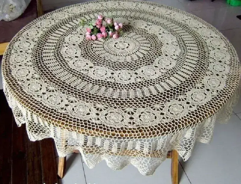 mesa de madeira com toalha de mesa redonda de crochê