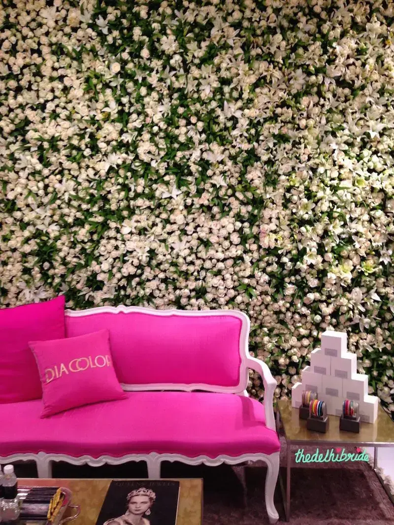 Decoração com painel de flores e sofá pink