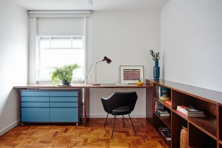 Home office branco com gaveteiro azul sob mesa de madeira Projeto de Iná Arquitetura