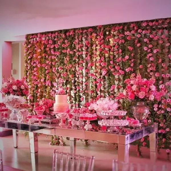 Mesa de bolo com painel de flores na decoração
