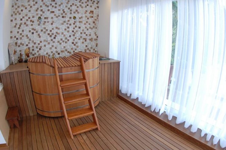 Ofurô de madeira em ambiente interno com deck de madeira Projeto de Monica Spada Durante