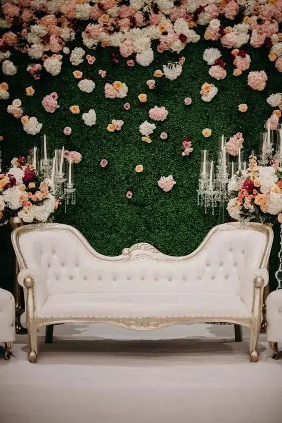 Painel de flores com sofá pequeno para fotos