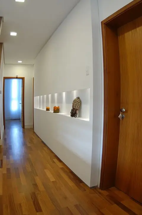 Parede de drywall com nicho embutido em corredor de acesso aos dormitórios Projeto de Mônica Spada Durante