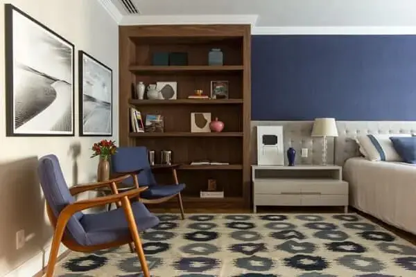 quarto de casal com parede azul combinando com as poltronas