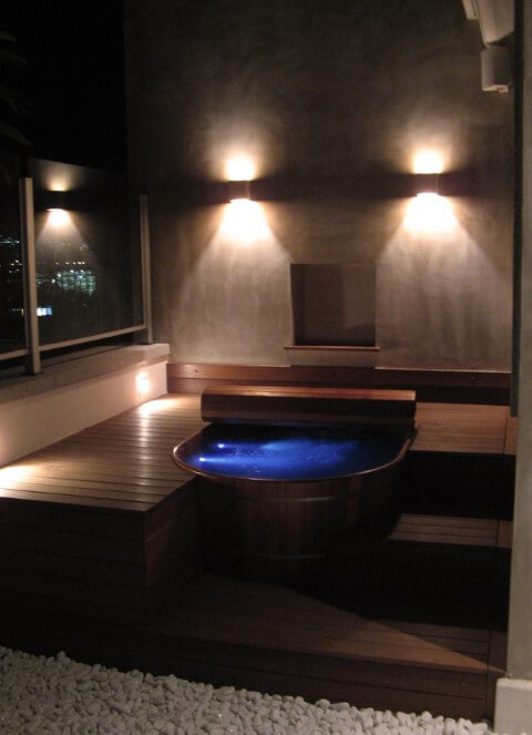 Sala de banho com ofurô com iluminação noturna Projeto de Andre Martins
