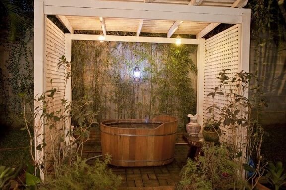 Sala de banho externa com ofurô de madeira Projeto de Cactus Arquitetura