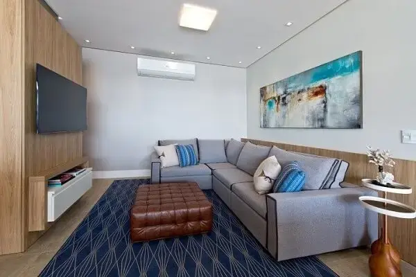 sala de estar com tapete, almofadas e quadro em tons de azul