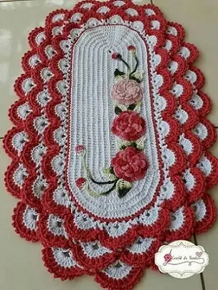Tapete de crochê oval com flores vermelhas e rosas