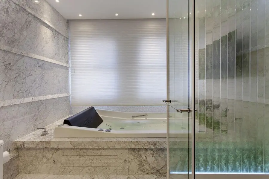 banheiro com banheira de hidro com revestimento de mármore carrara