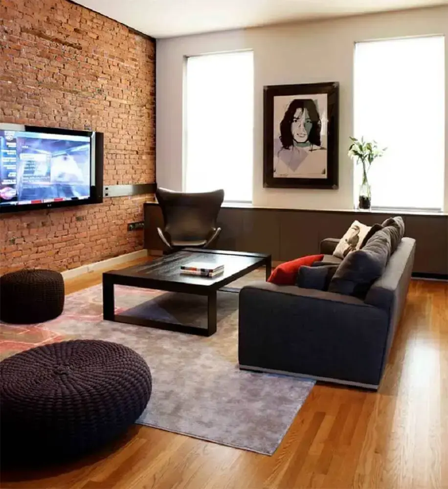 decoração sala de TV com parede de tijolinho e piso de madeira