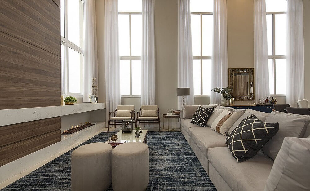 paleta de cores bege para sala de estar sofisticada decorada com lareira e tapete azul