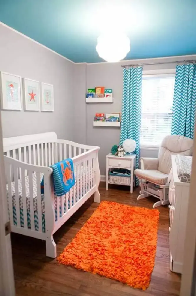 quarto de bebê pequeno decorado com tapete laranja