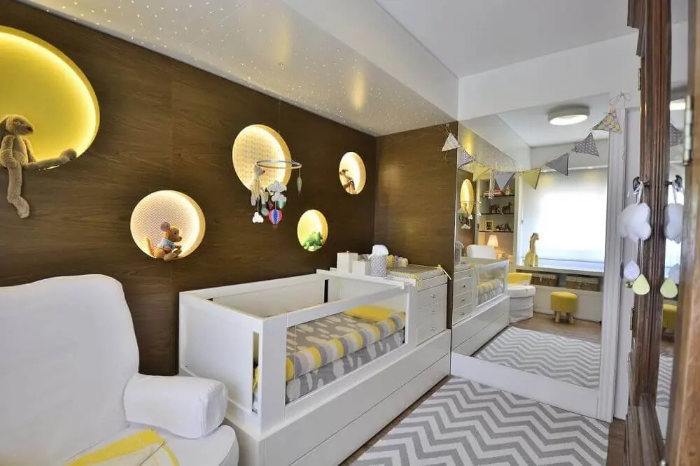 quarto de bebê pequeno planejado com painel de madeira e nichos com iluminação embutida