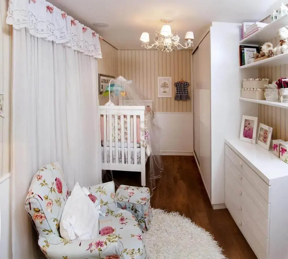 quarto de bebê pequeno planejado com papel de parede listrado e poltrona de amamentação com estampa floral