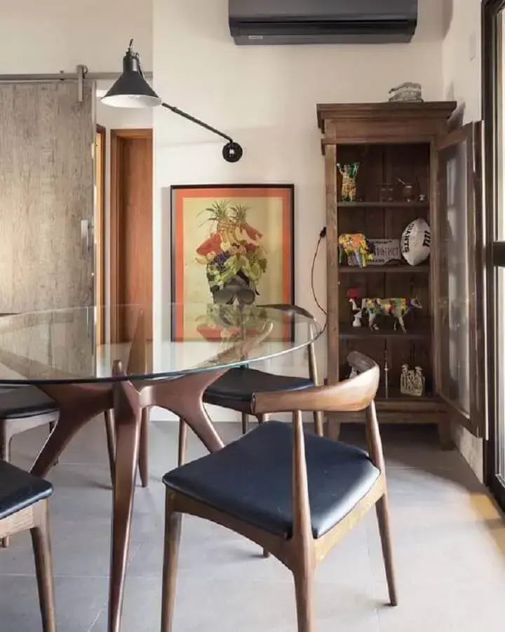 sala de jantar decorada com mesa de vidro redonda com base moderna de madeira Foto Histórias de Casa