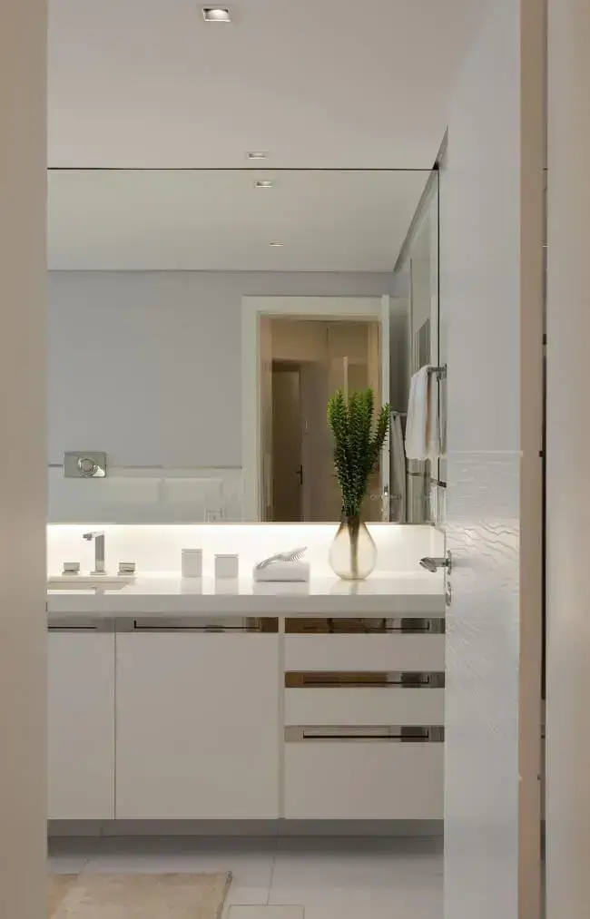 A iluminação embutida na espelheira traz um charme para os banheiros modernos