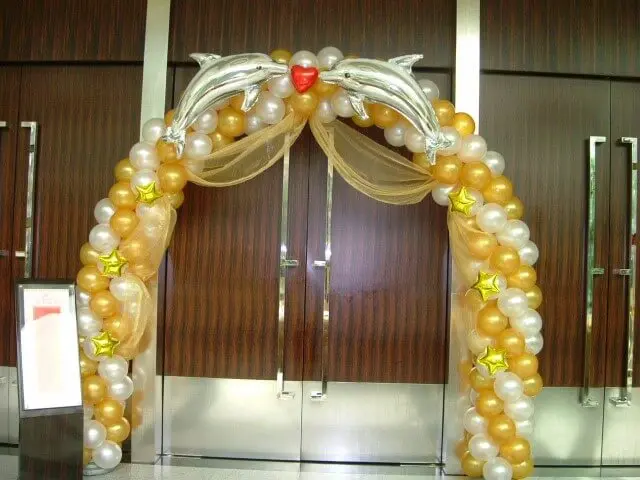 Arco de bexiga amarelo e dourado com balões de de golfinho Foto de Amazon