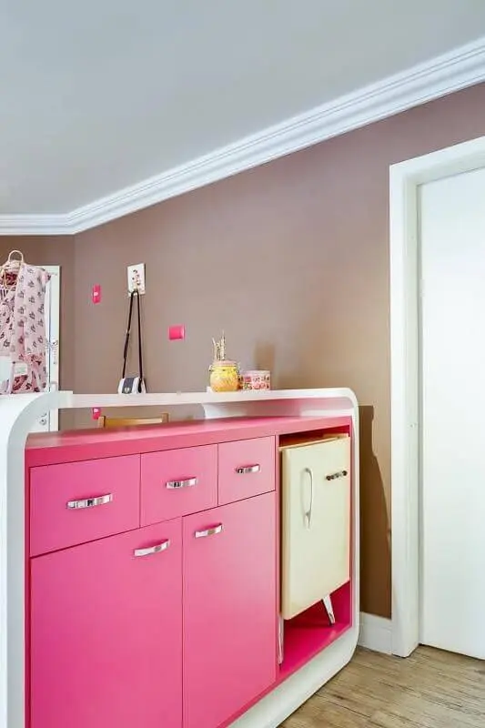 Atelier com armário em tons de rosa pink e frigobar Projeto de Juliana Lahoz