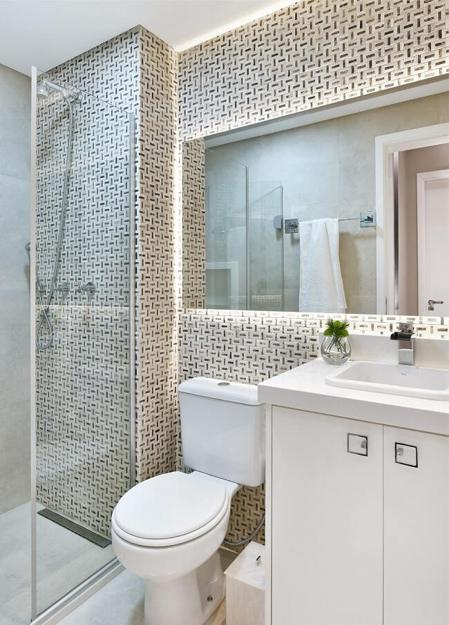 Banheiros modernos com espelho iluminado e marcenaria branca