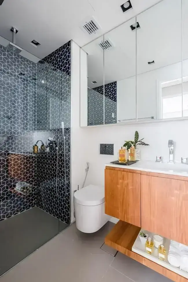 Banheiros modernos com revestimento geométrico e móvel de madeira