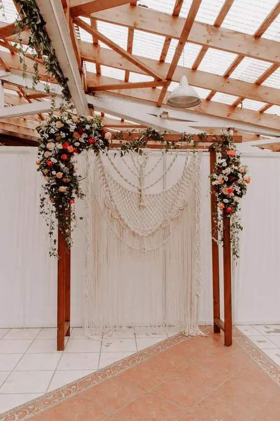 Estrutura de madeira com macrame e flores na decoração
