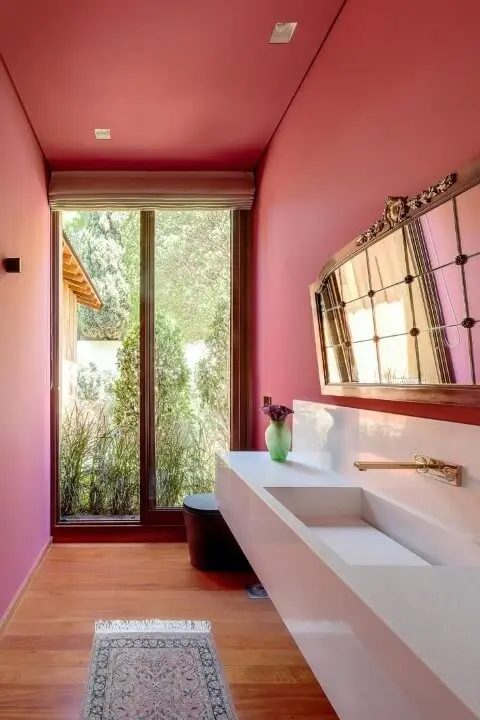 Lavabo com parede em tons de rosa com balcão amplo branco Projeto de AMC Arquitetura