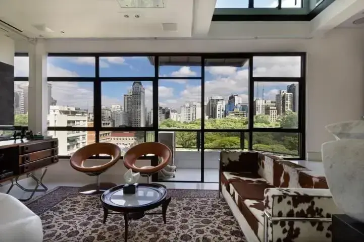 Loft com janelas amplas e decoração rústica Projeto de Urbano Studio