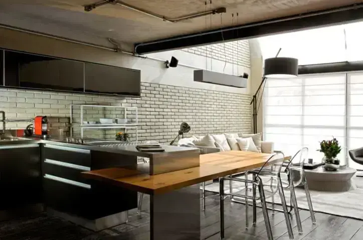Loft com mesa de jantar acoplada à bancada Projeto de Diego Revollo