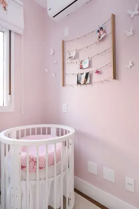 Quarto de bebê com berço e parede em tons de rosa Projeto de By Arquitetura
