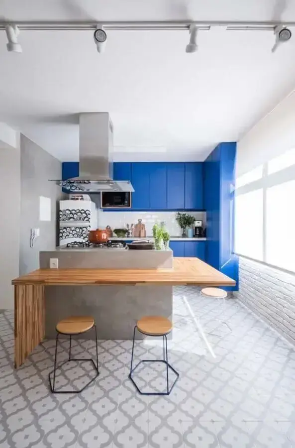 cozinha moderna decorada com armário azul royal e ilha de cimento queimado com bancada de madeira Foto Mauricio Gebara Arquitetura