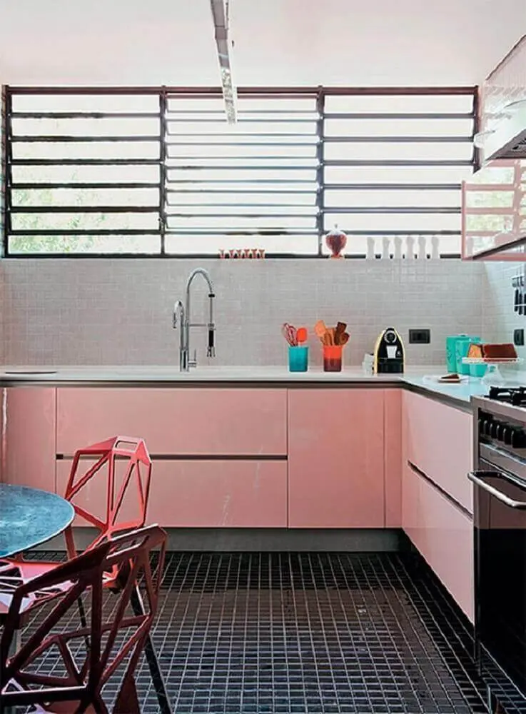 cozinha retrô decorada com armário rosa e piso preto 