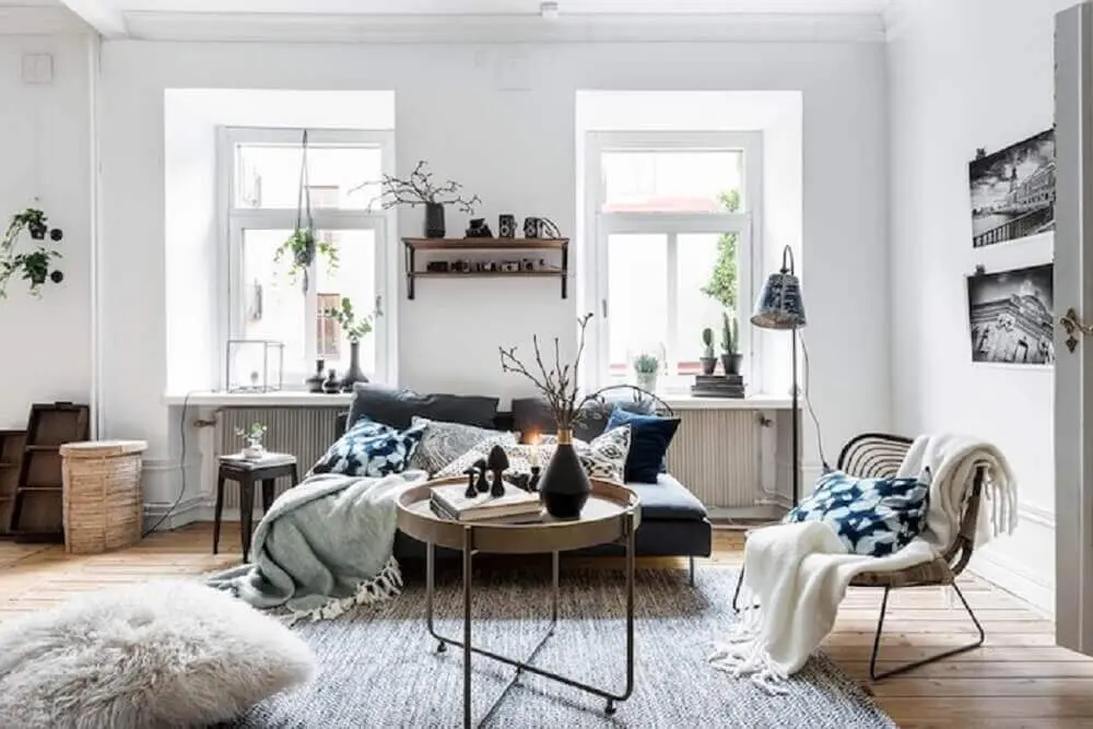 decoração hygge para sala com janelas amplas e muitas almofadas e mantas sobre o sofá Foto Pinterest
