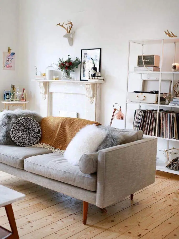 decoração hygge para sala com piso de madeira sofá cinza e manta decorativa Foto Deavita