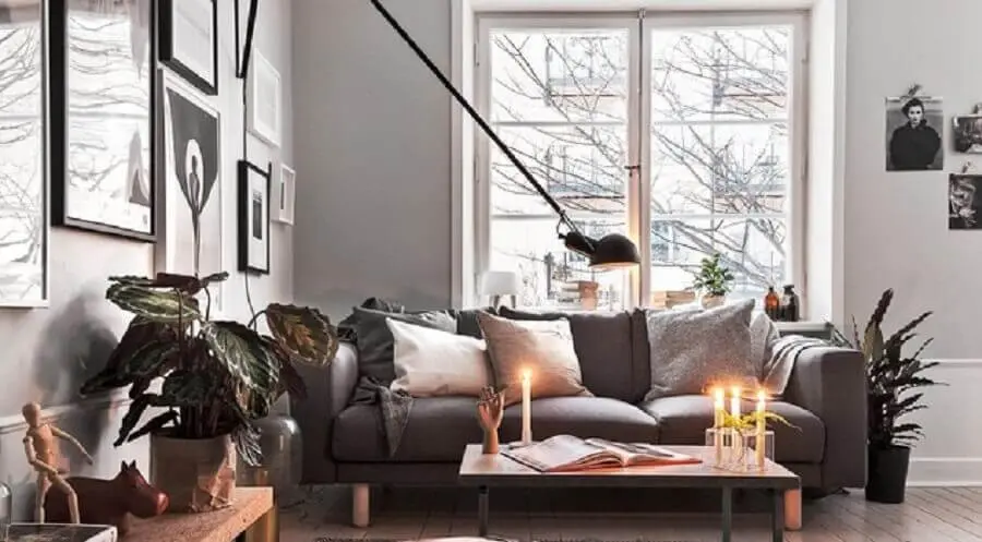 decoração hygge para sala de estar com luminária de parede e plantas Foto Ansa