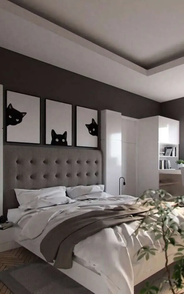 decoração quarto com parede cinza quadros e cabeceira capitonê casal