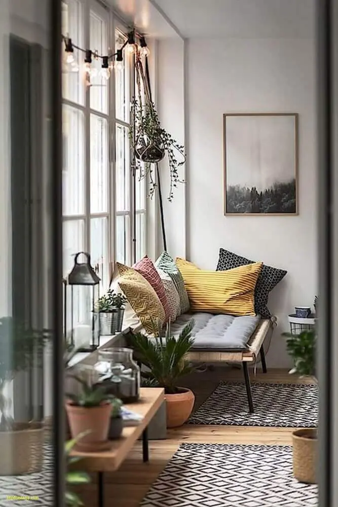 estilo hygge para decoração com varal de lâmpadas tapete com estampa geométrica e almofadas coloridas Foto Fontana
