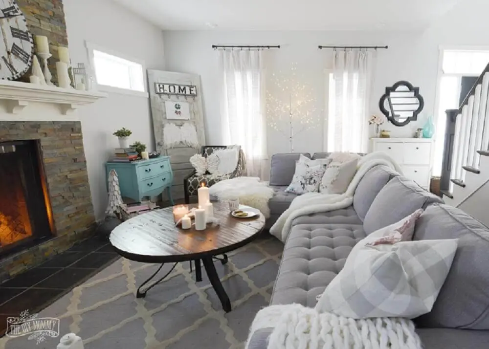 estilo hygge para sala de estar com sofá cinza aparador azul tiffany e lareira Foto The DIY Mommy