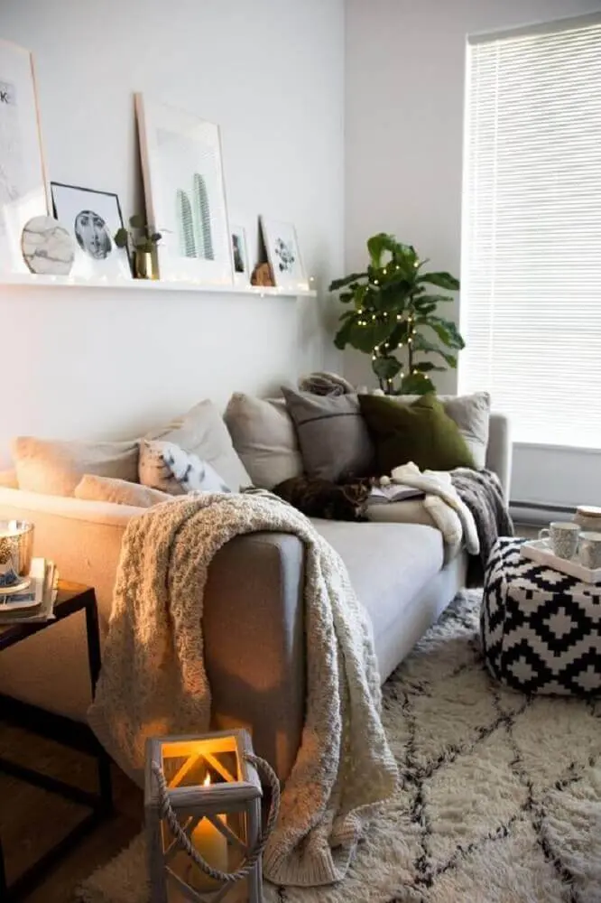hygge decor para sala de estar com muitas almofadas manta sobre o sofá e puff preto e branco Foto Home Decor Idea
