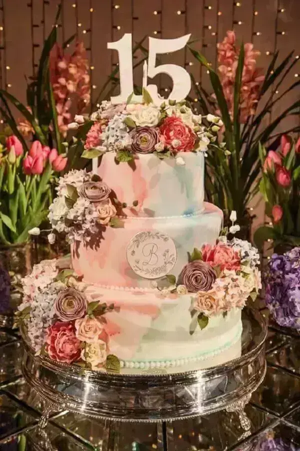 ideia de bolo para festa de 15 anos decorado com tons pastéis e flores