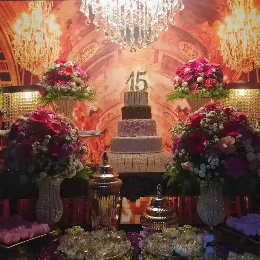 lustre de cristal e arranjo de flores para festa de 15 anos com decoração sofisticada