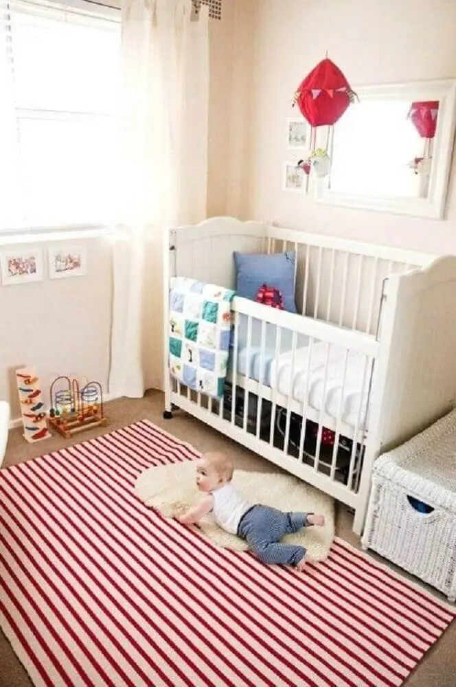 quarto de bebê decorado com tapete listrado vermelho e branco 