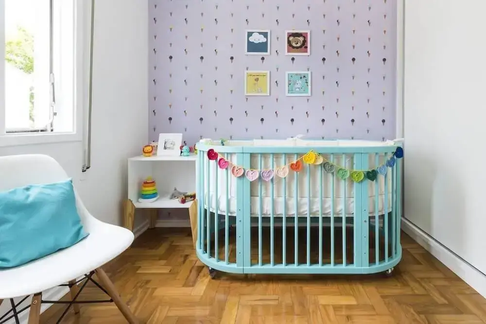 quarto de bebê simples e pequeno decorado com papel de parede de sorvetinho e berço azul Foto Pinterest
