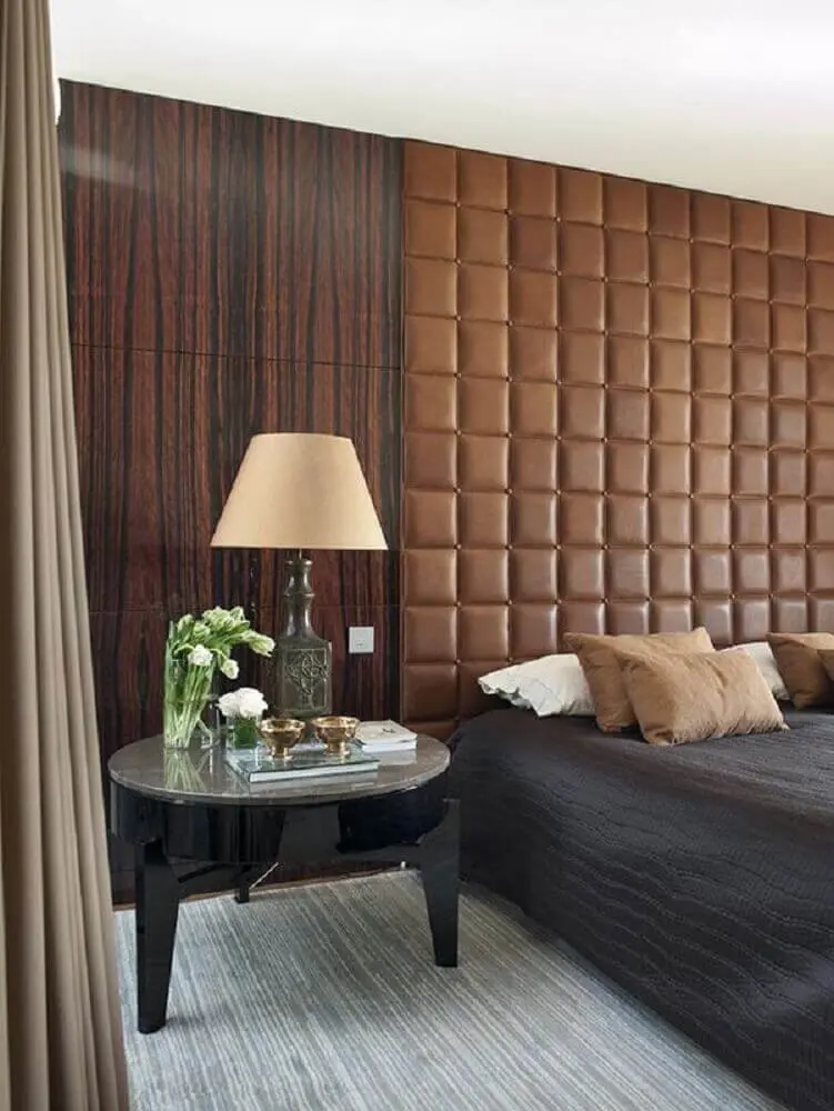 quarto de casal com parede revestida de madeira e cabeceira capitonê de couro marrom - Foto Light House