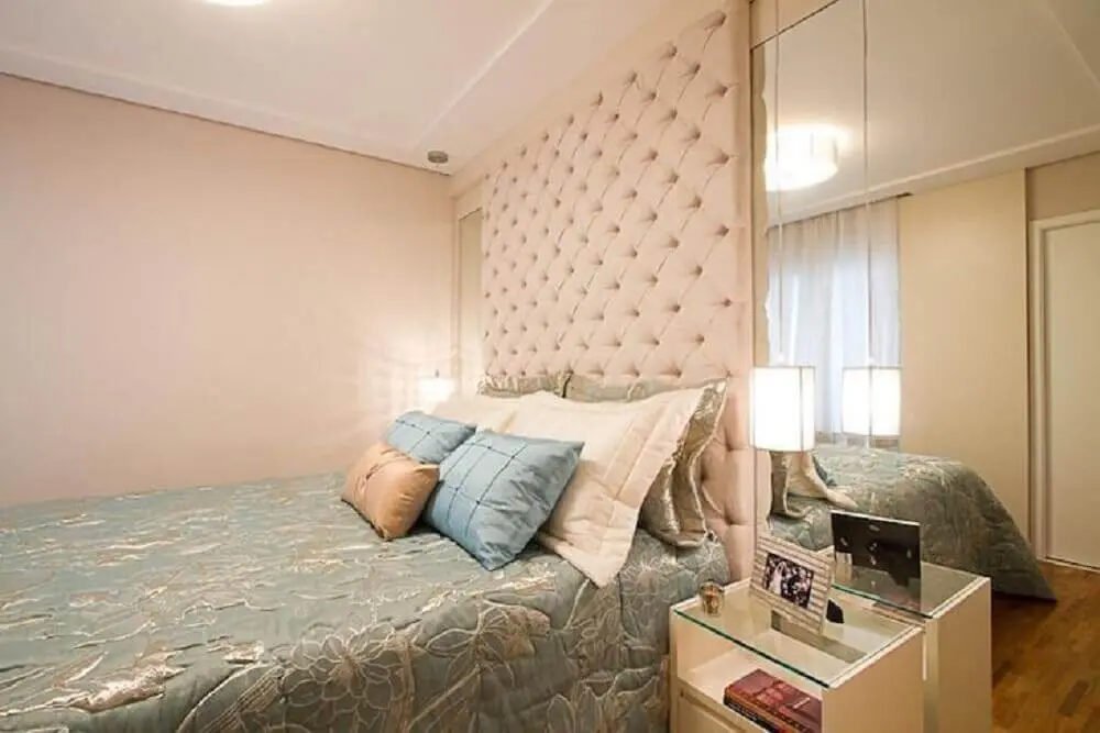 quarto decorado com parede espelhada e cabeceira de cama capitonê - Foto Sartori Design