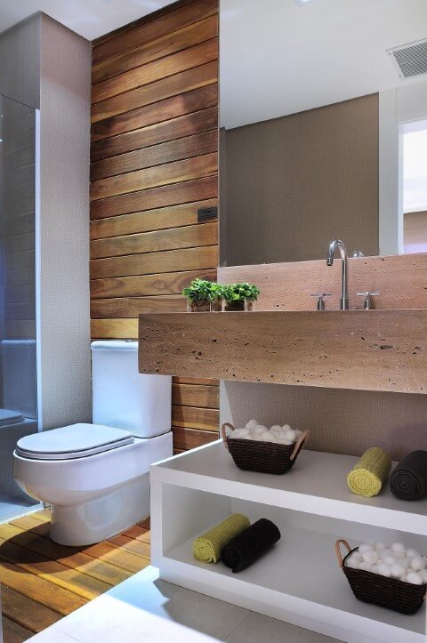 Banheiro com acabamento em madeira e bacia com caixa acoplada Foto de Quitete Faria